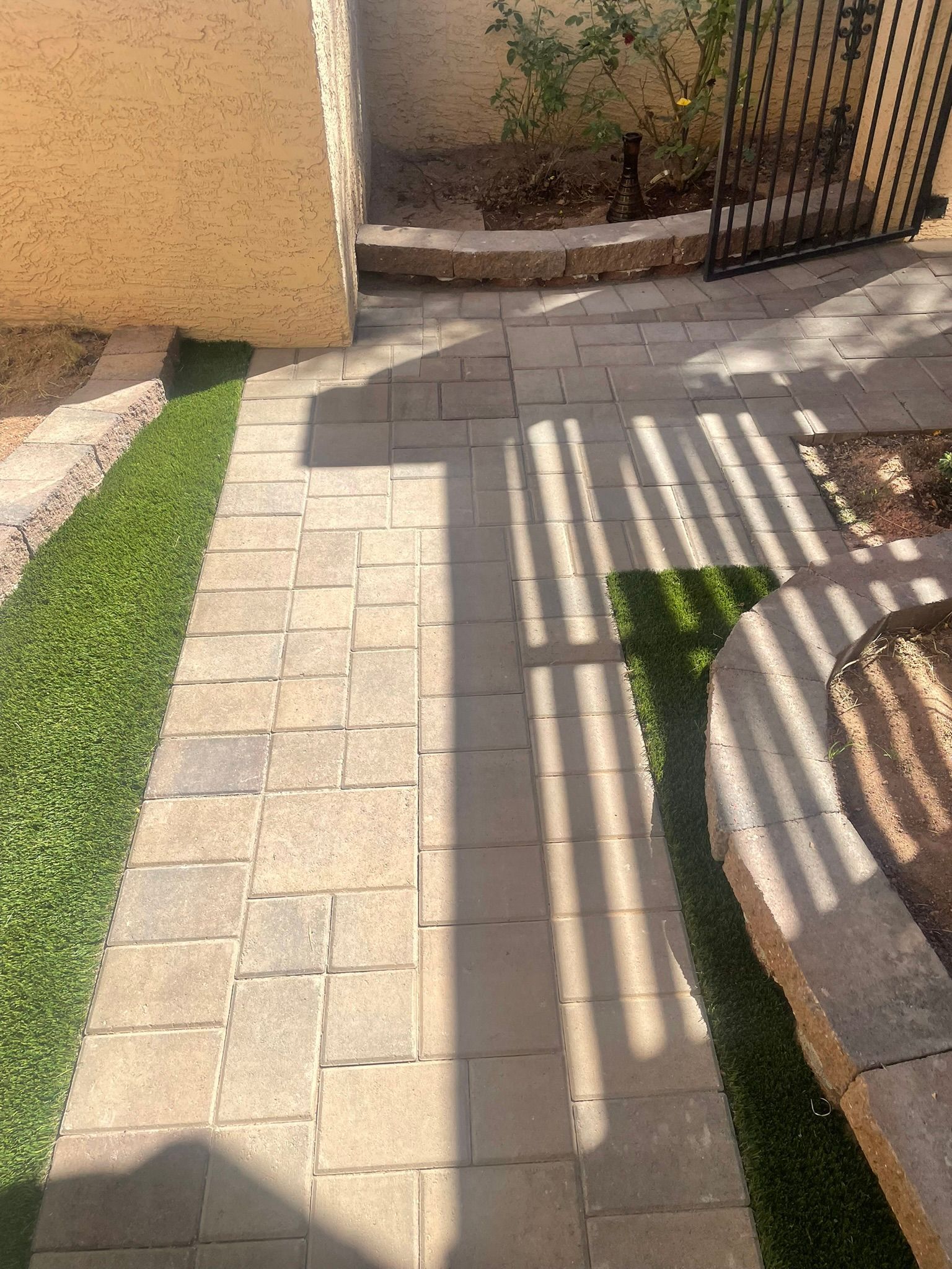 A shadow of a person is cast on a brick walkway.