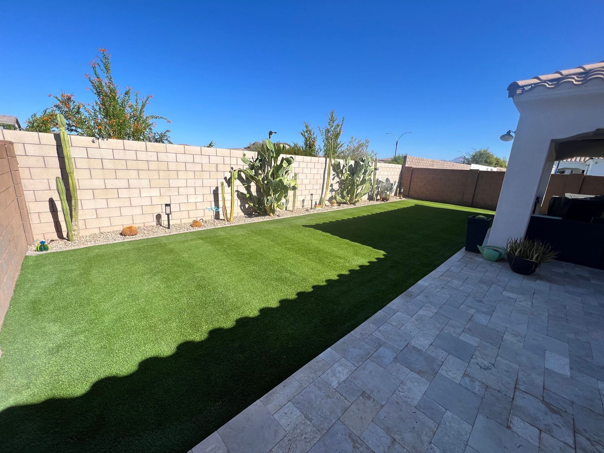A backyard with a patio and a brick wall