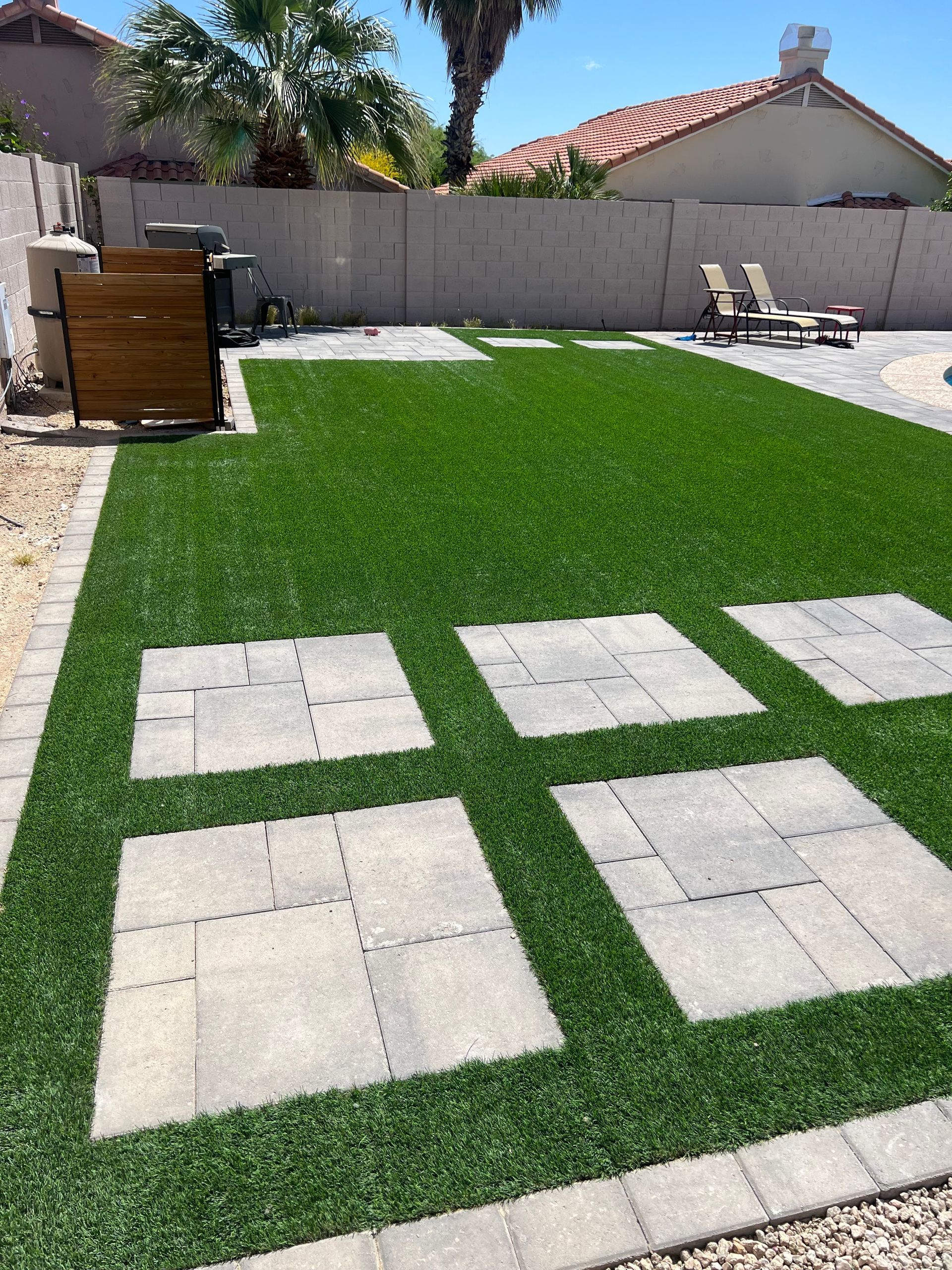 A backyard with a lot of grass and bricks