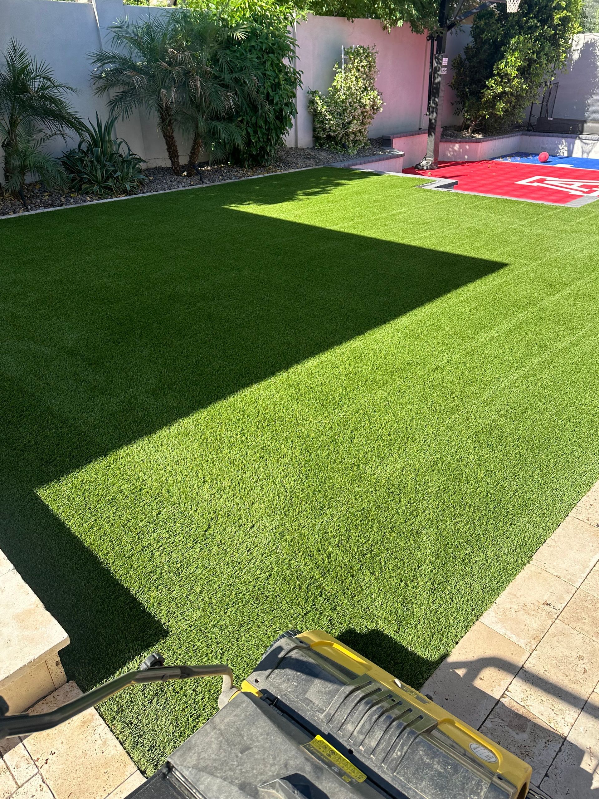 A yard with a lot of green grass and a toolbox on the ground.