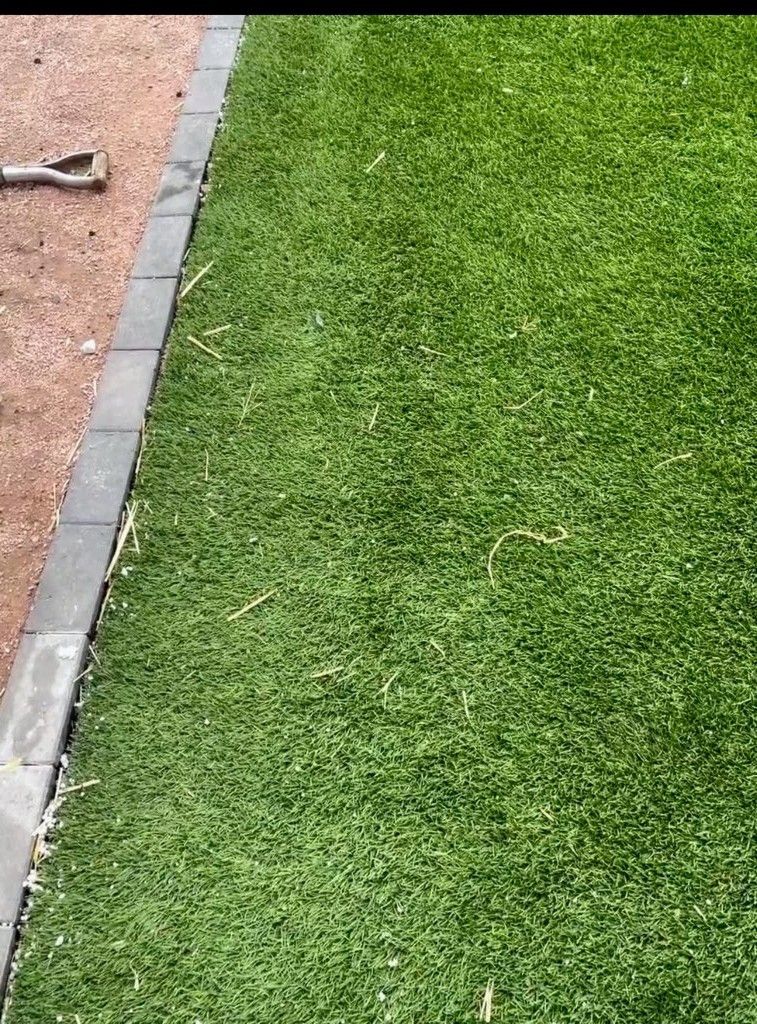A close up of a lawn with a hammer on the ground.