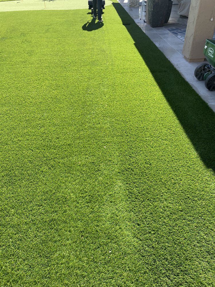 A person is standing on a lush green lawn.