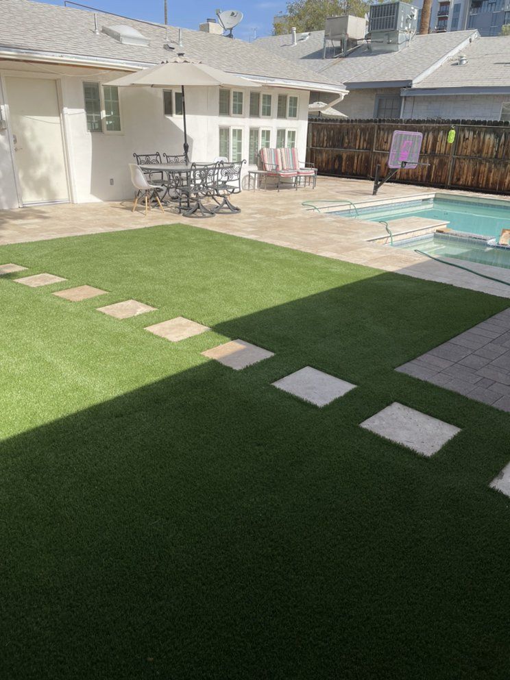 A backyard with a swimming pool and a table and chairs.