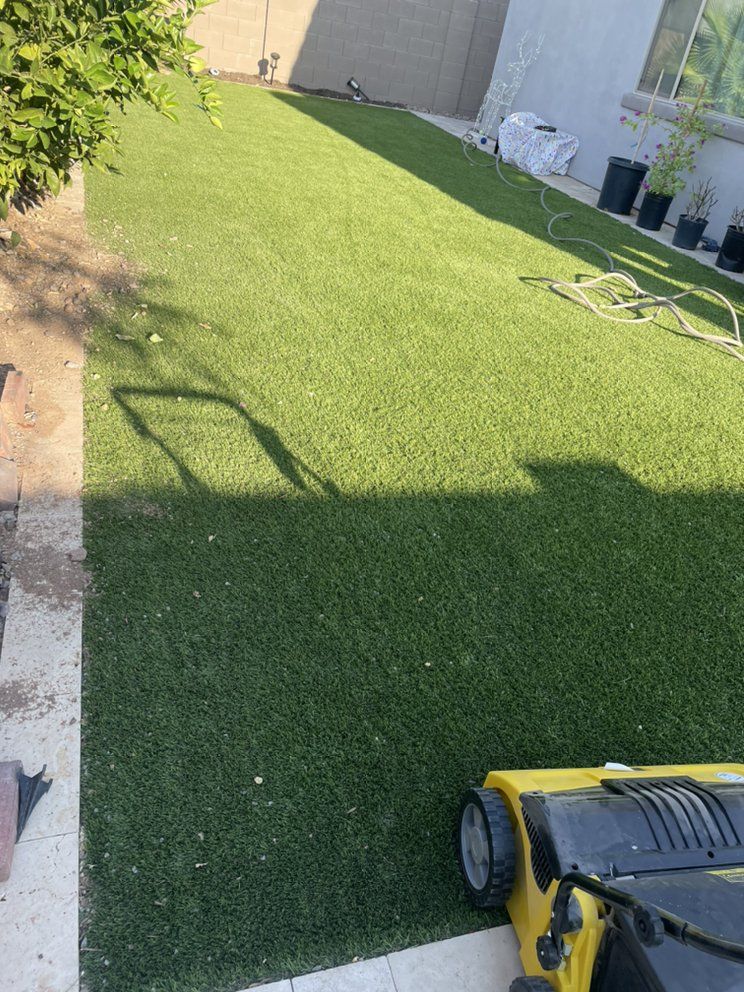 A yellow lawn mower is sitting on top of a lush green lawn.