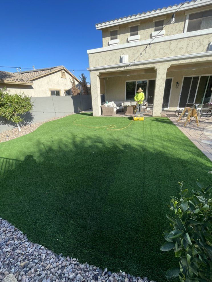 A backyard with a lot of grass and a house in the background.