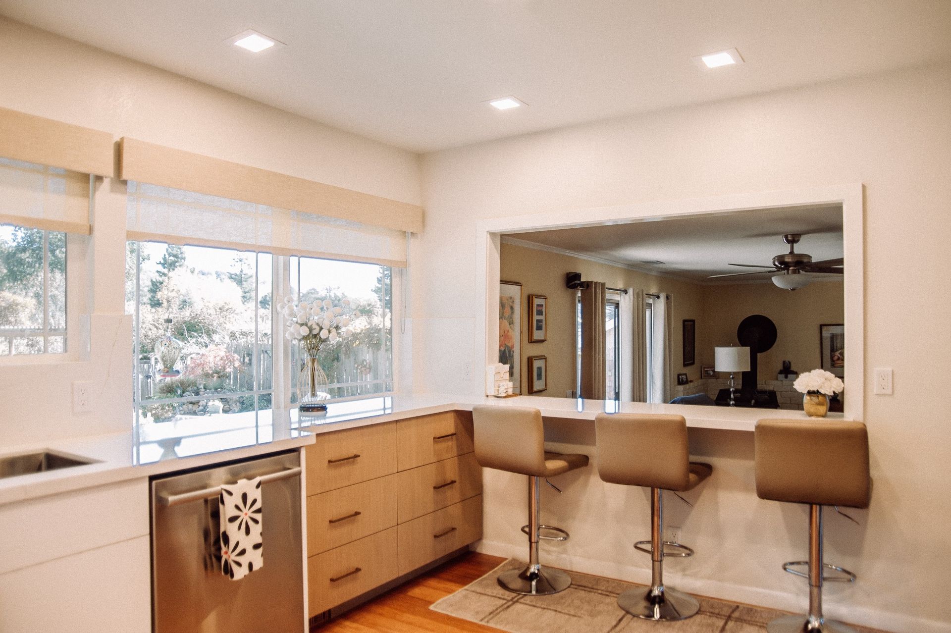 Modern kitchen bar area with light wood cabinetry, white quartz countertop...