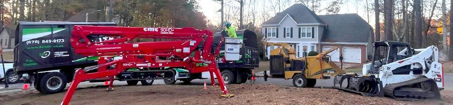 A group of construction vehicles are parked in front of a house.