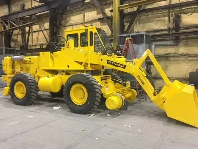 Yellow industrial front-end loader in a warehouse setting.