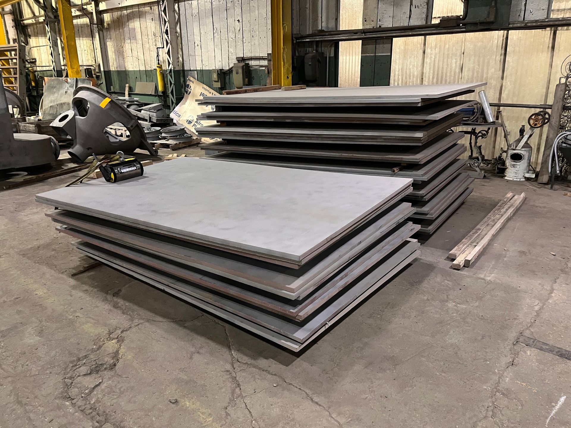 Deck with stainless steel railing and chairs overlooking a green field and mountains.