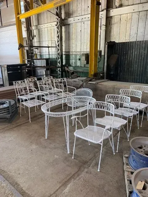 White metal patio table and chairs in an industrial building.