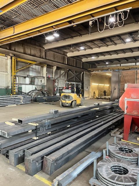 Warehouse interior with steel beams and a forklift.