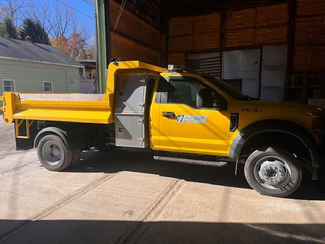 Yellow dump truck parked inside a warehouse.