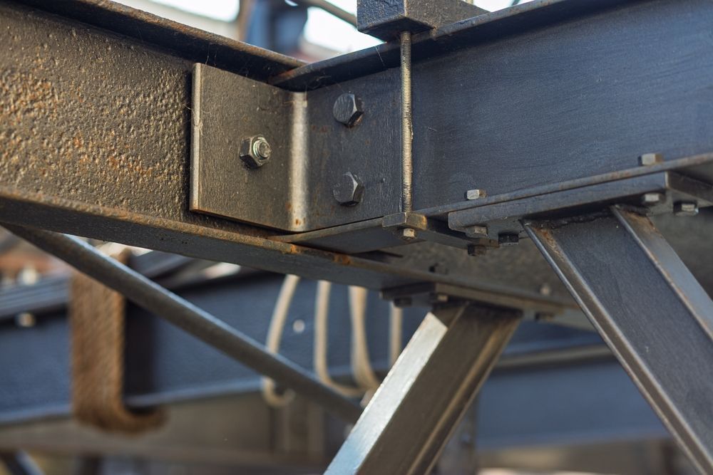 Warehouse interior with steel beams and a forklift.