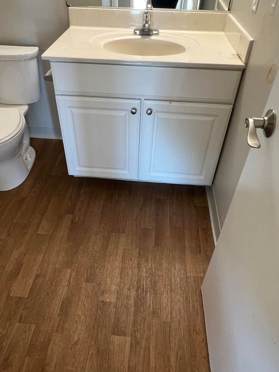 A bathroom with a sink , toilet and mirror.