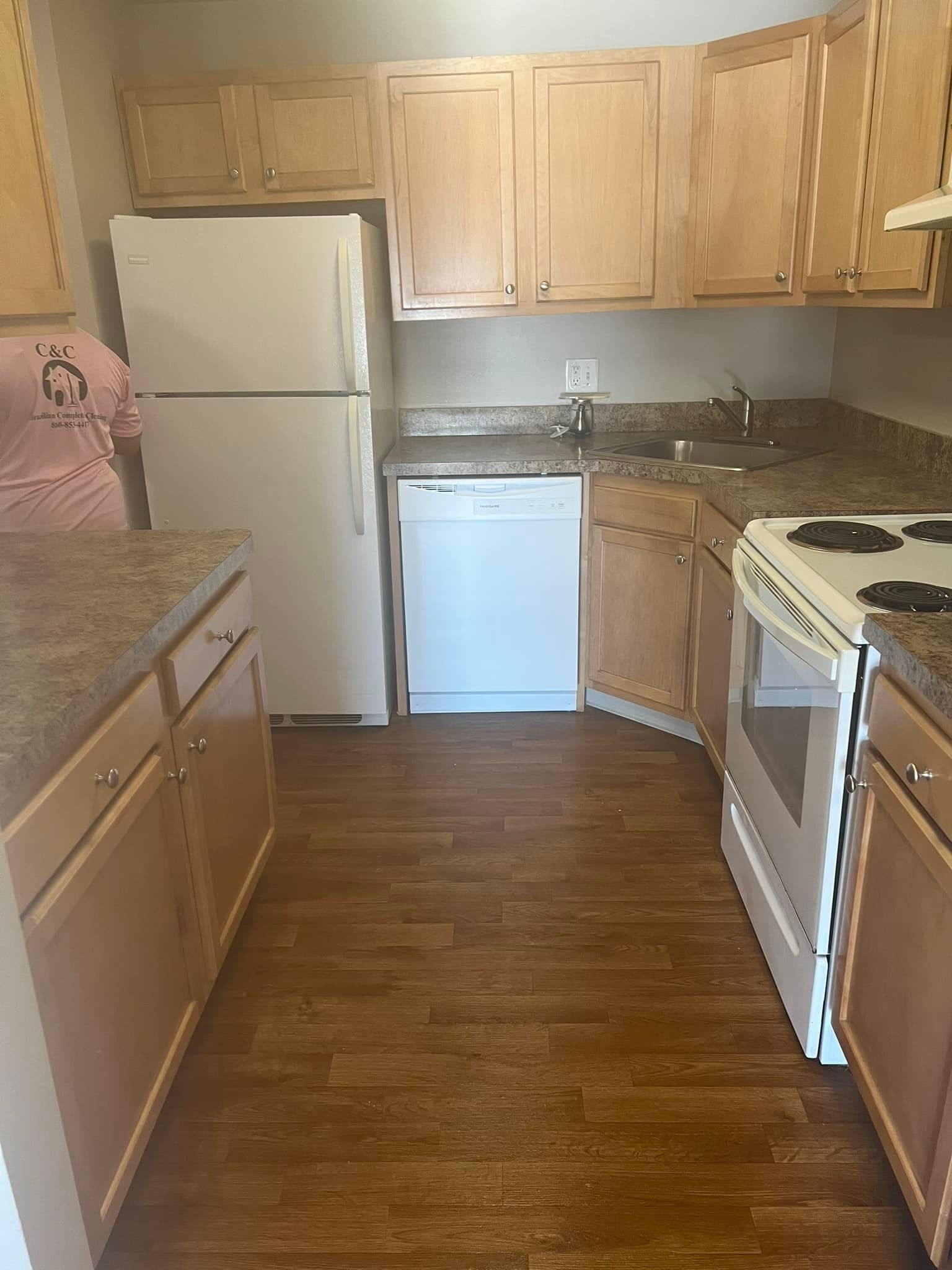 A kitchen with wooden cabinets , a refrigerator , a stove , and a dishwasher.