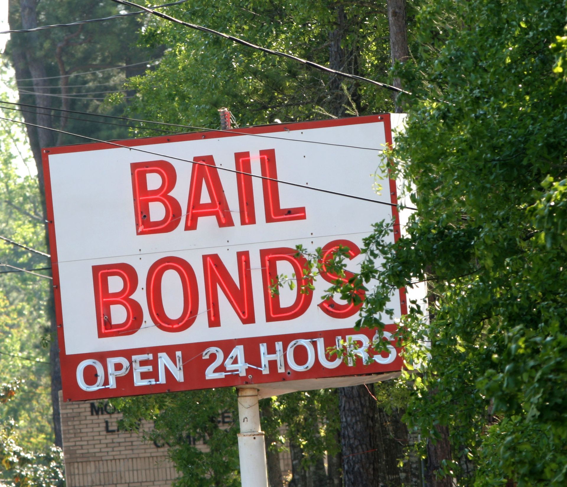 A red and white sign that says bail bonds open 24 hours