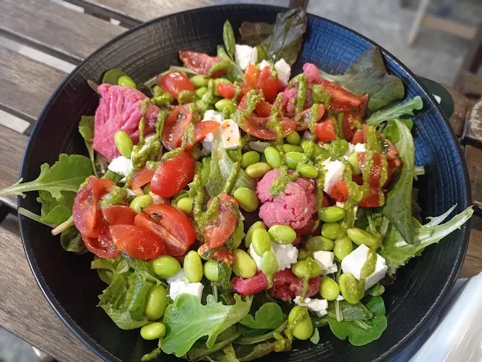 Insalatiera: verdure, edamame, pomodori, feta, cavolfiore rosa, condimento verde.