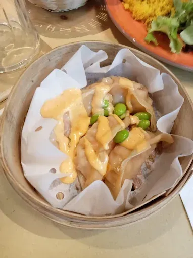 Gnocchi con salsa ed edamame in una ciotola di legno su un tavolo.