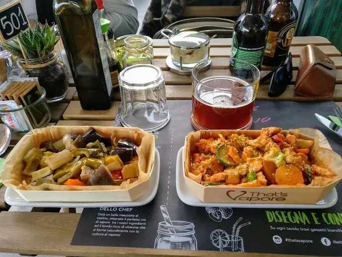 Due pasti in scatole di legno, bevande e decorazioni su un tavolo in un ristorante.