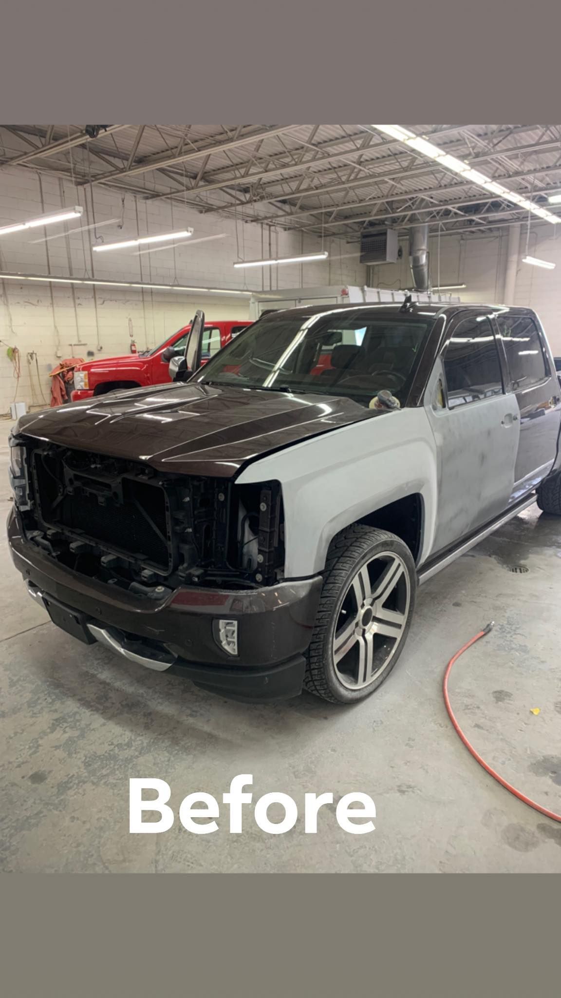 Grey pickup truck in a body shop, ready for paint.