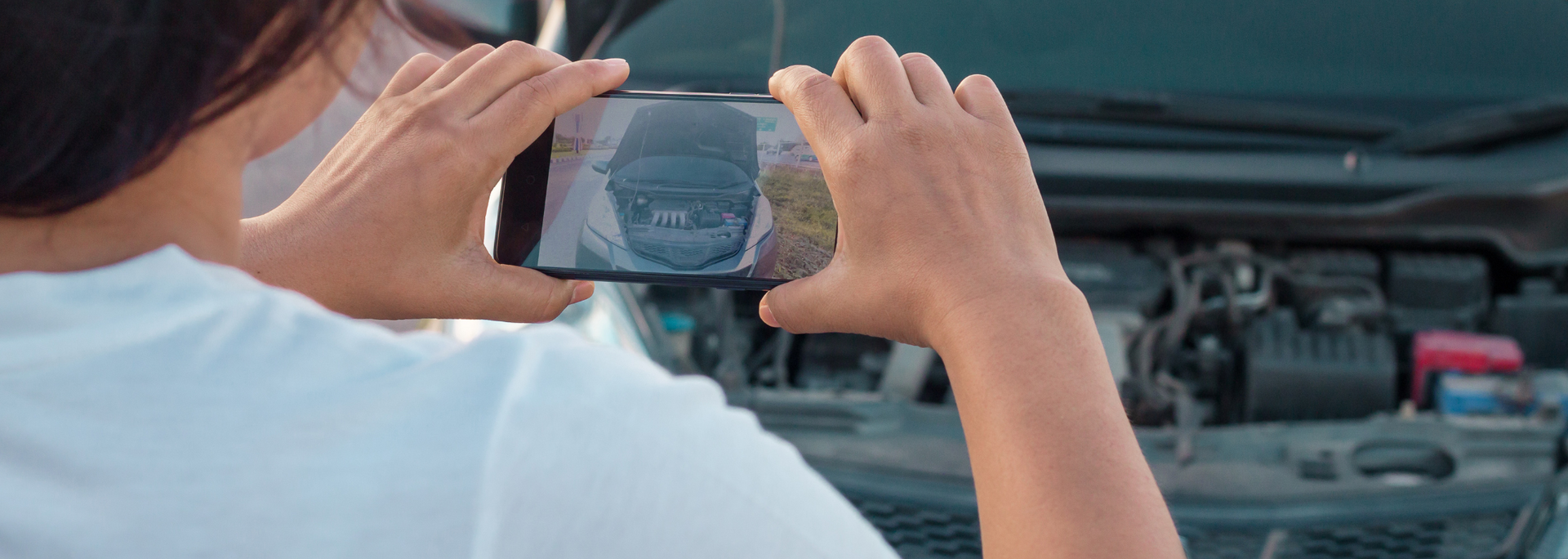 Picture of someone taking a photo of a car