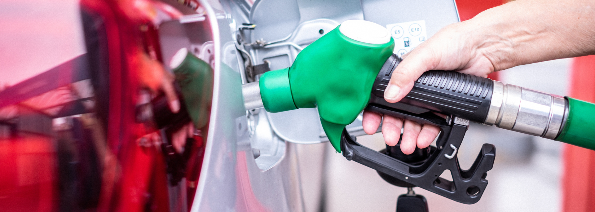 Picture of someone filling up their car with fuel. 