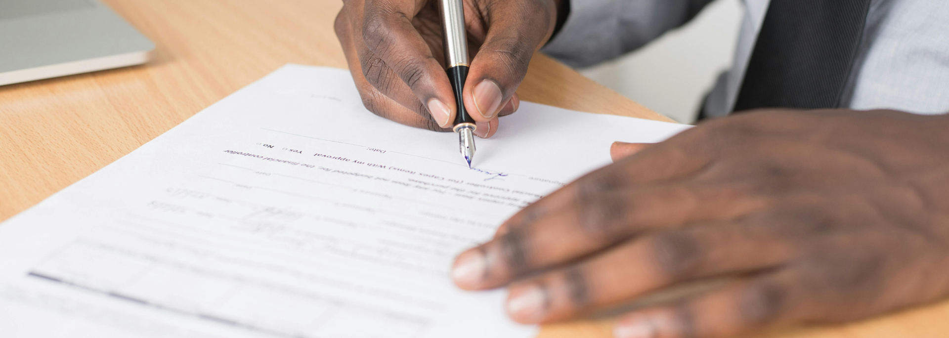 Picture of someone signing a document. 
