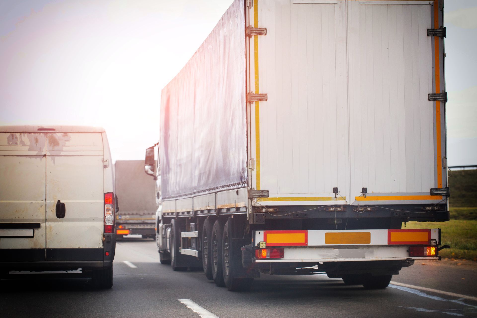 Long-distance moving truck driving on the highway with other vehicles.