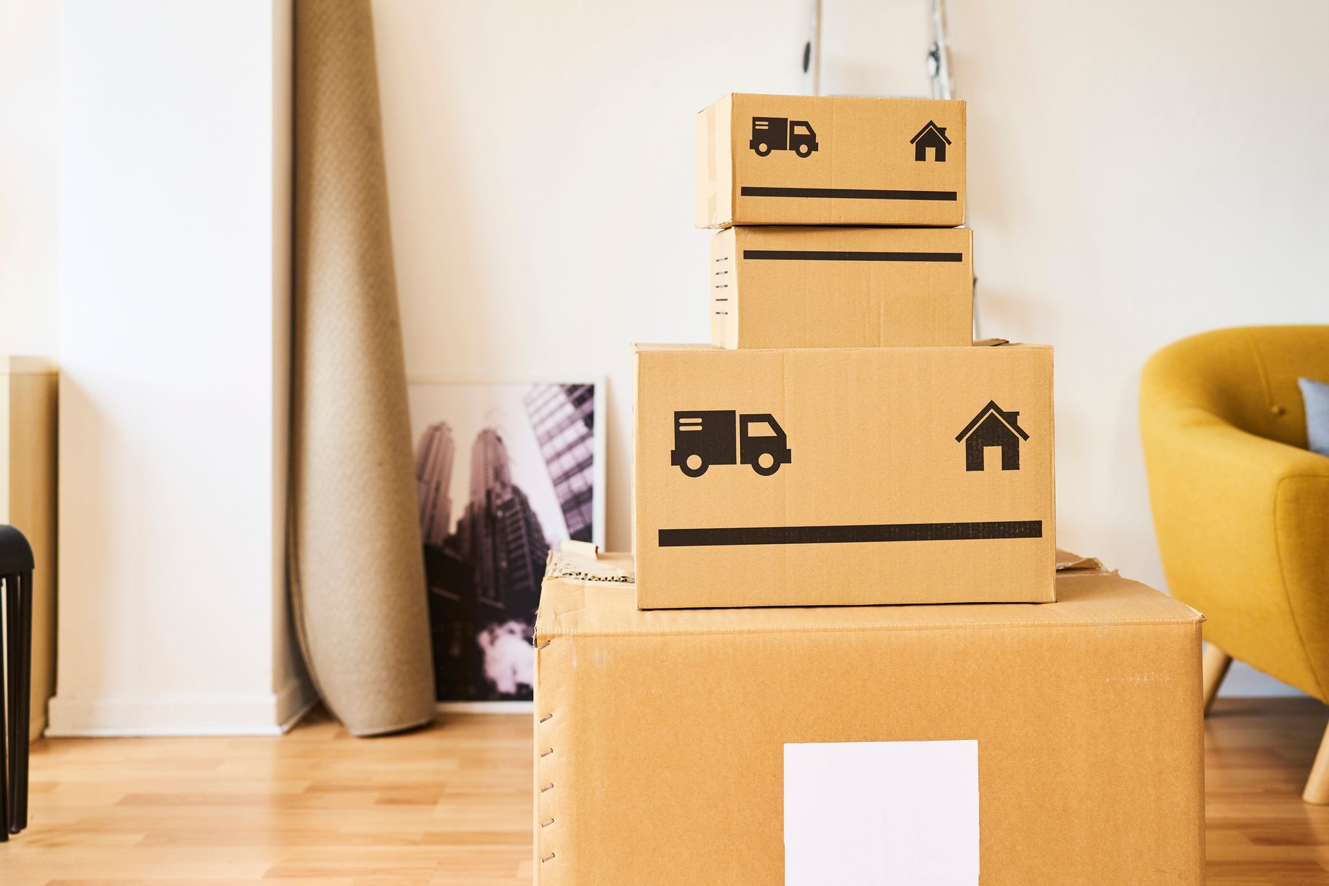 Stacked cardboard boxes with moving icons in a living room.