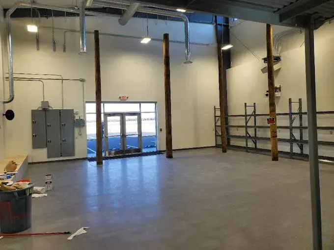 A large empty room with wooden poles and shelves