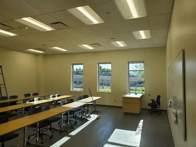 A classroom with tables and chairs and a white board