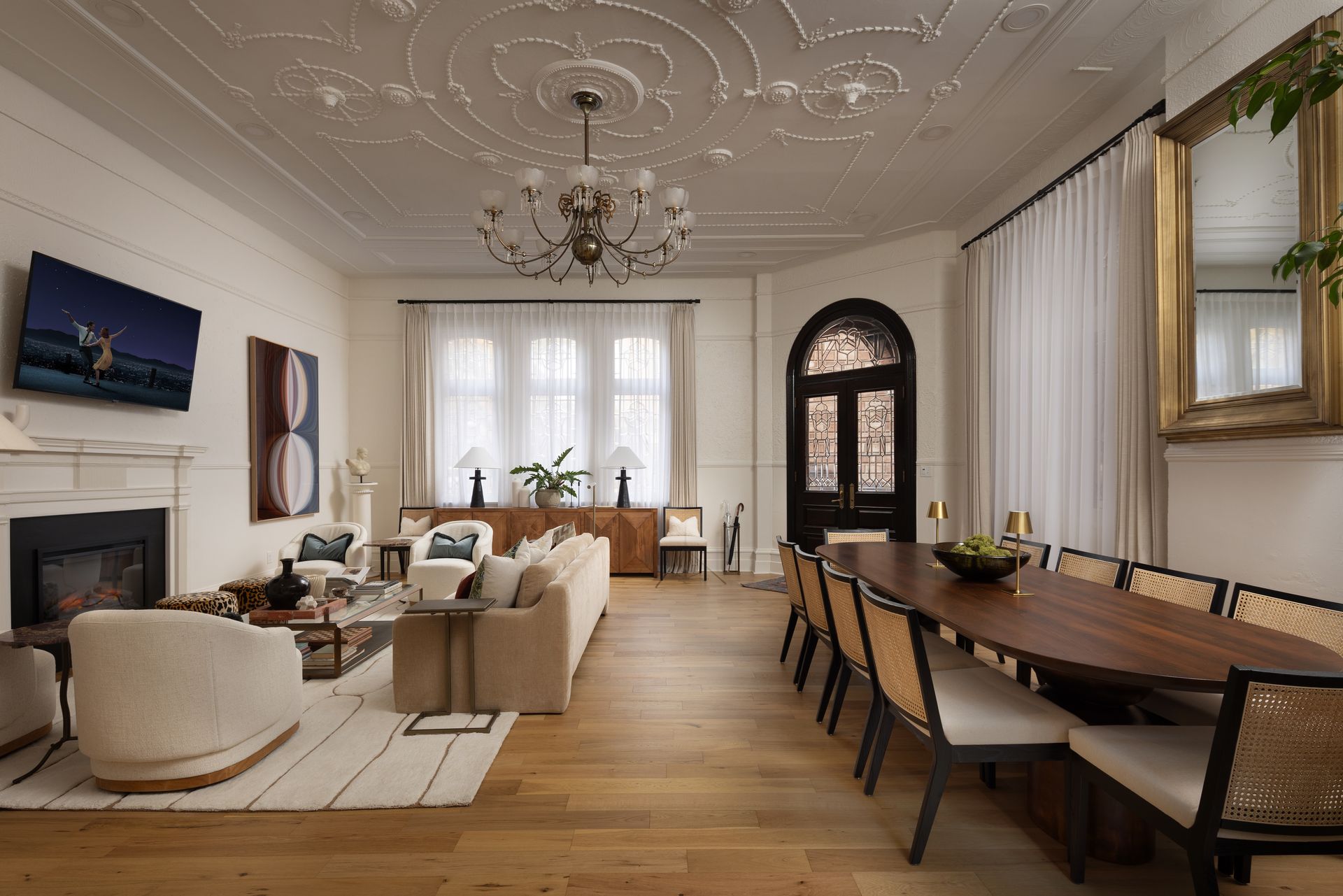 A living room with a dining table and chairs and a fireplace.