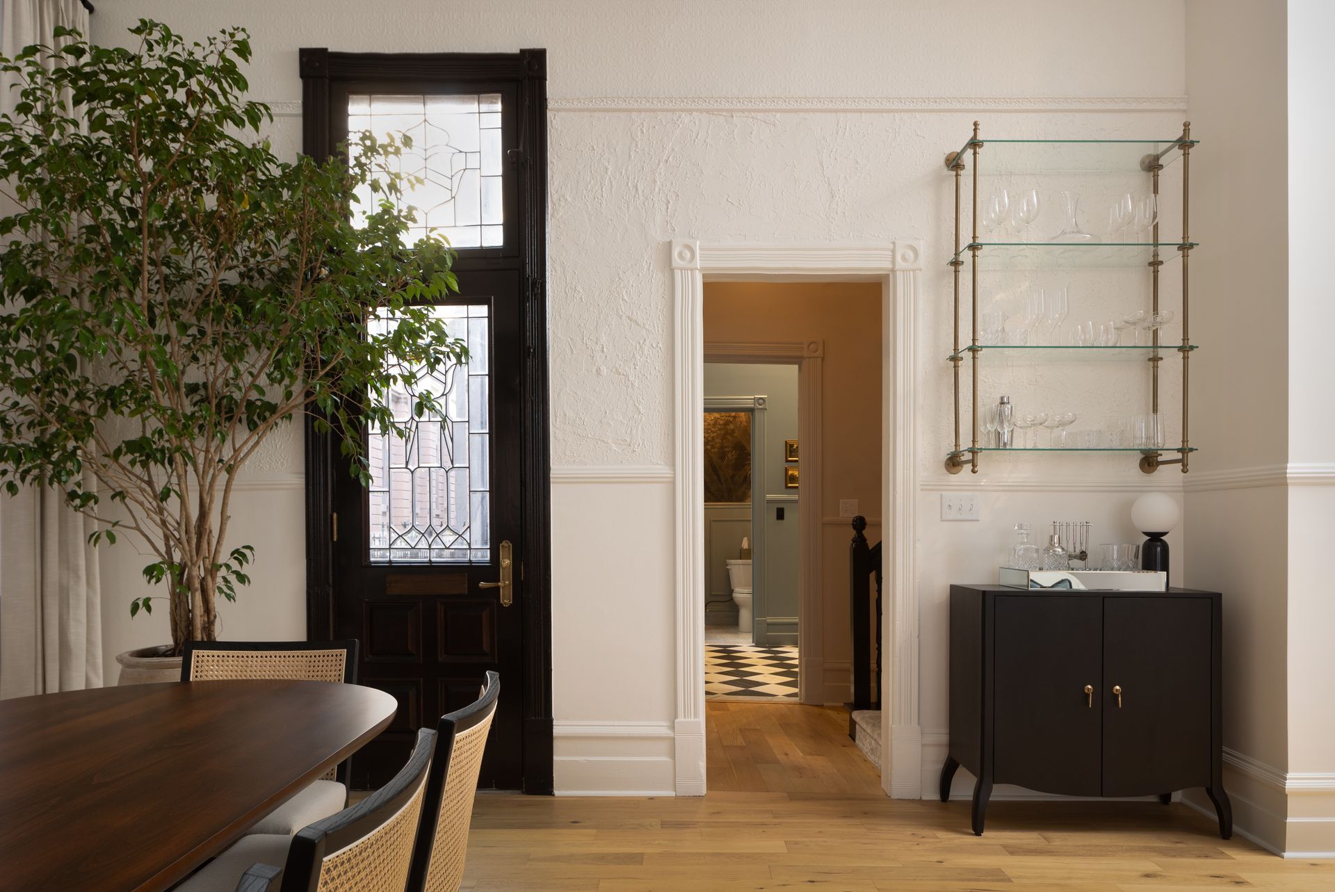 A dining room with a table , chairs , and a black door.
