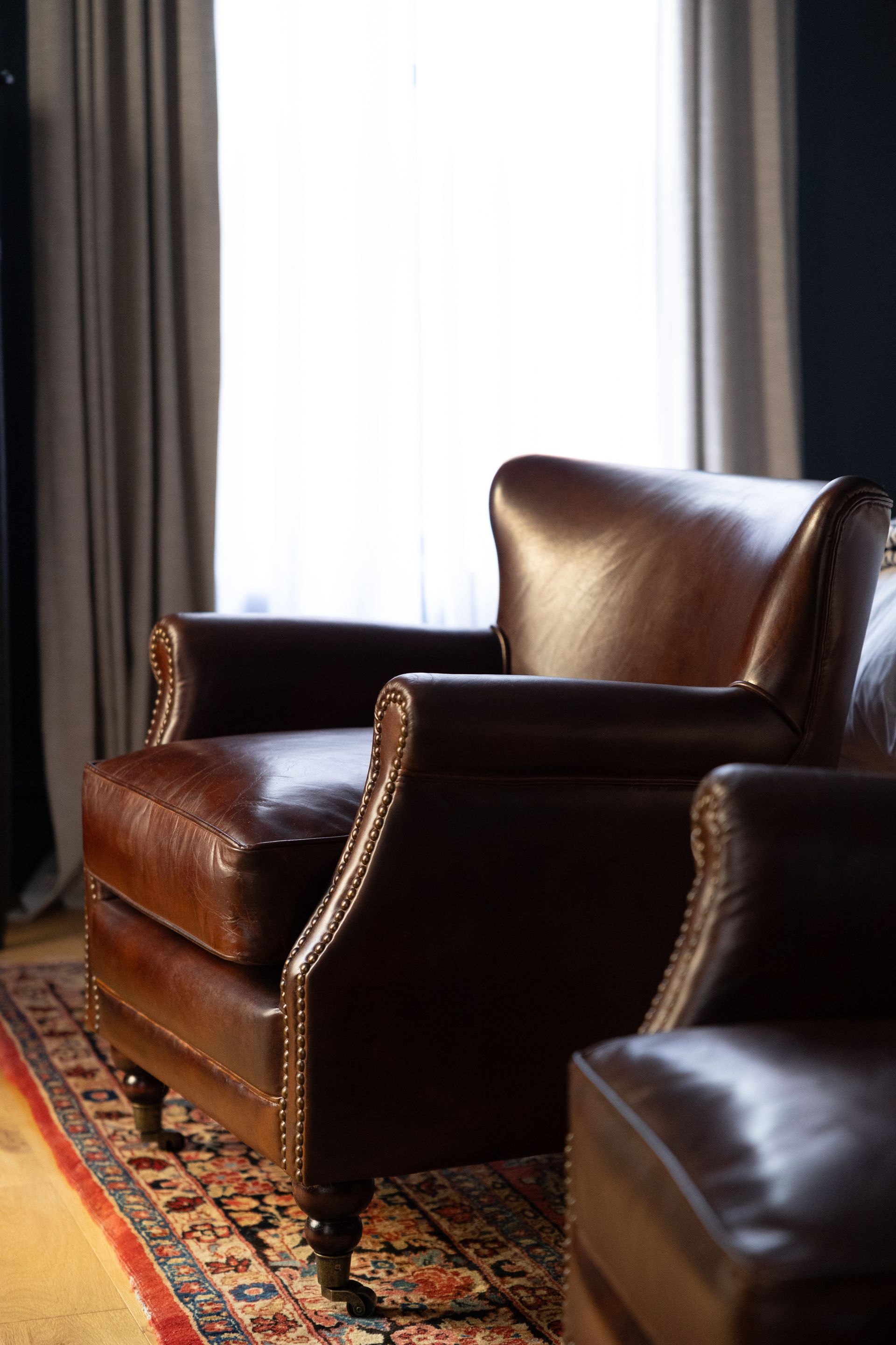 Two brown leather chairs are sitting next to each other in a living room.