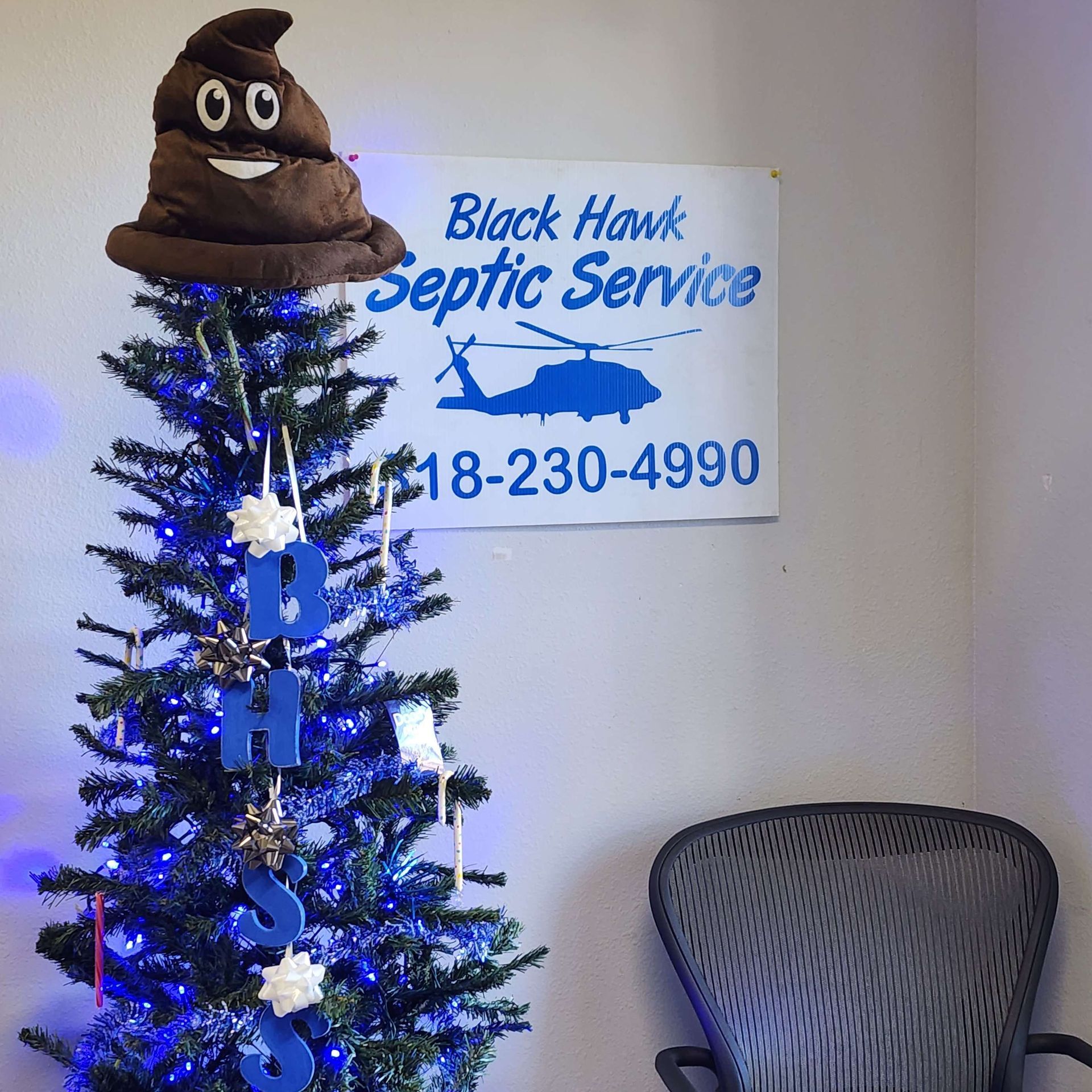 Christmas tree topped with poop emoji, in front of 