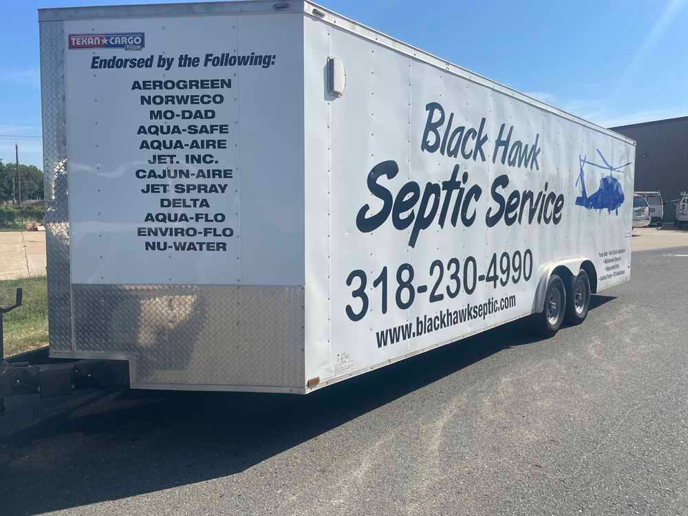 White trailer for Black Hawk Septic Service, with phone number and endorsements listed on the side.