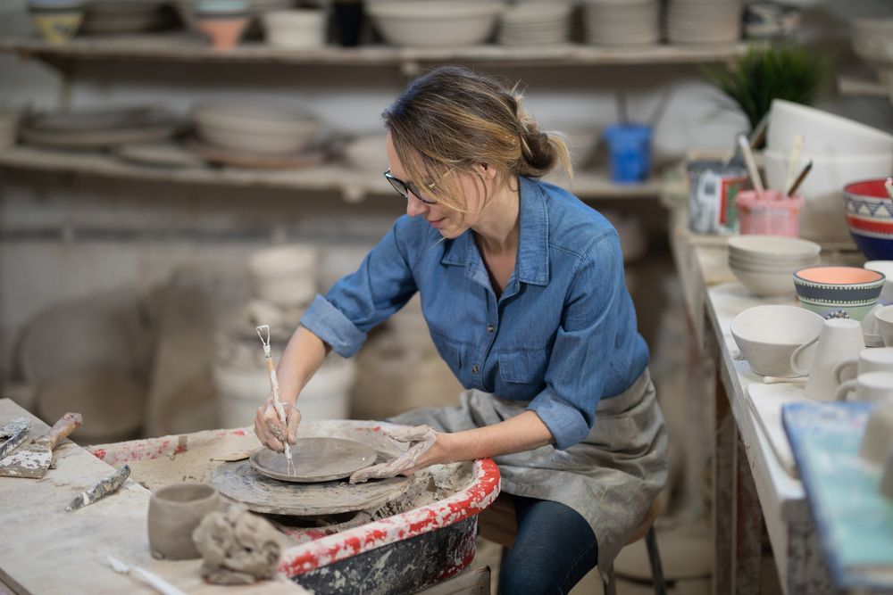 woman working in her pottery workshop in a pole barn