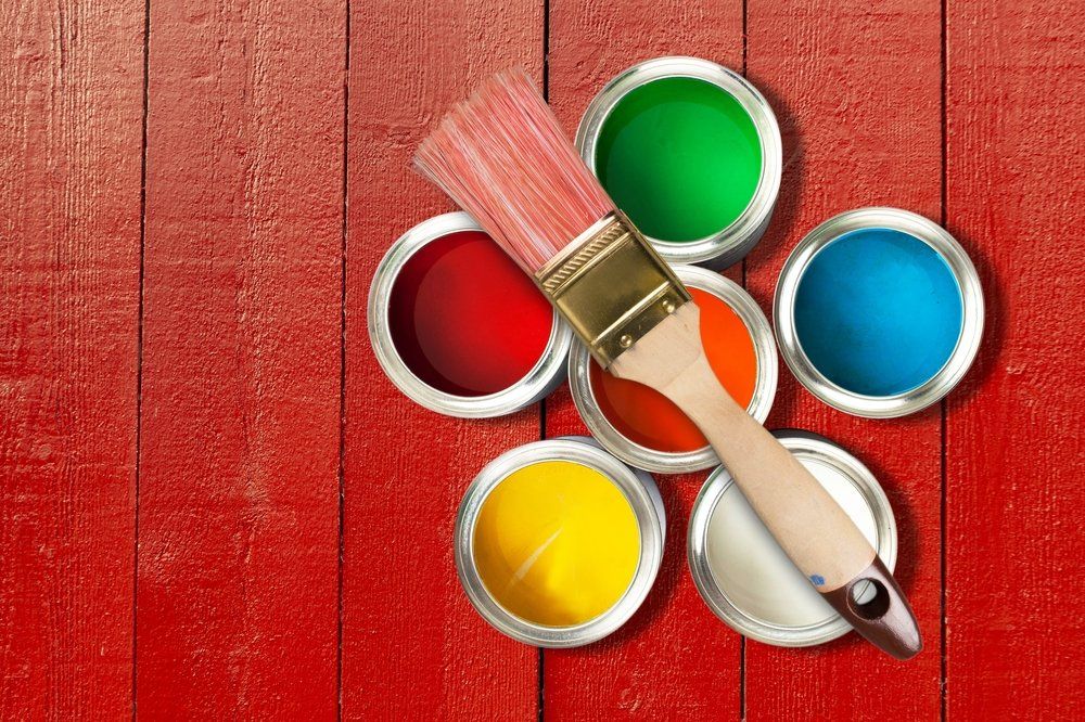 paint cans with different colors on a red floor boards