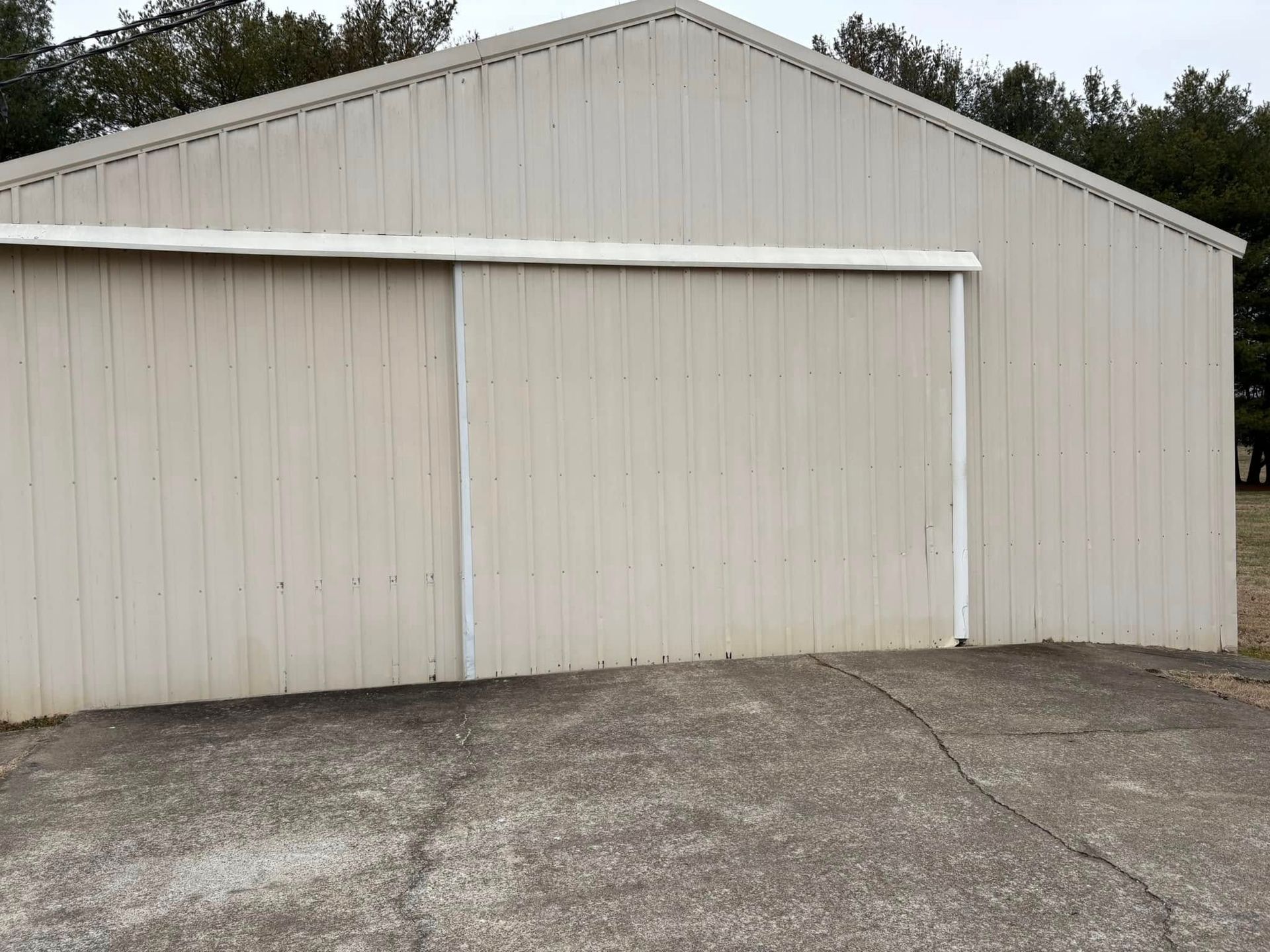 Tan metal building with a sliding door.