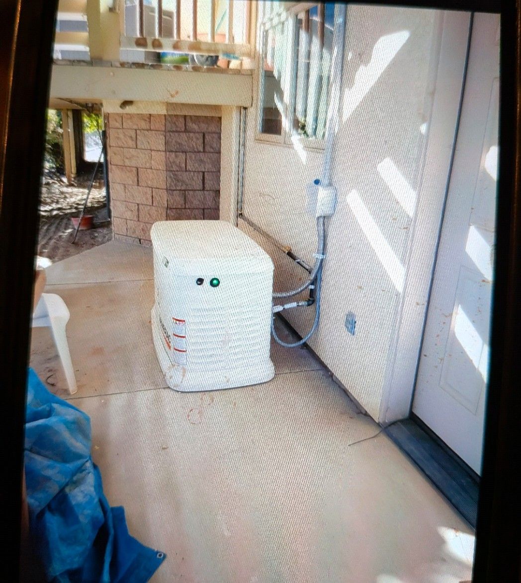 White spa machine next to a textured wall under a wooden deck.