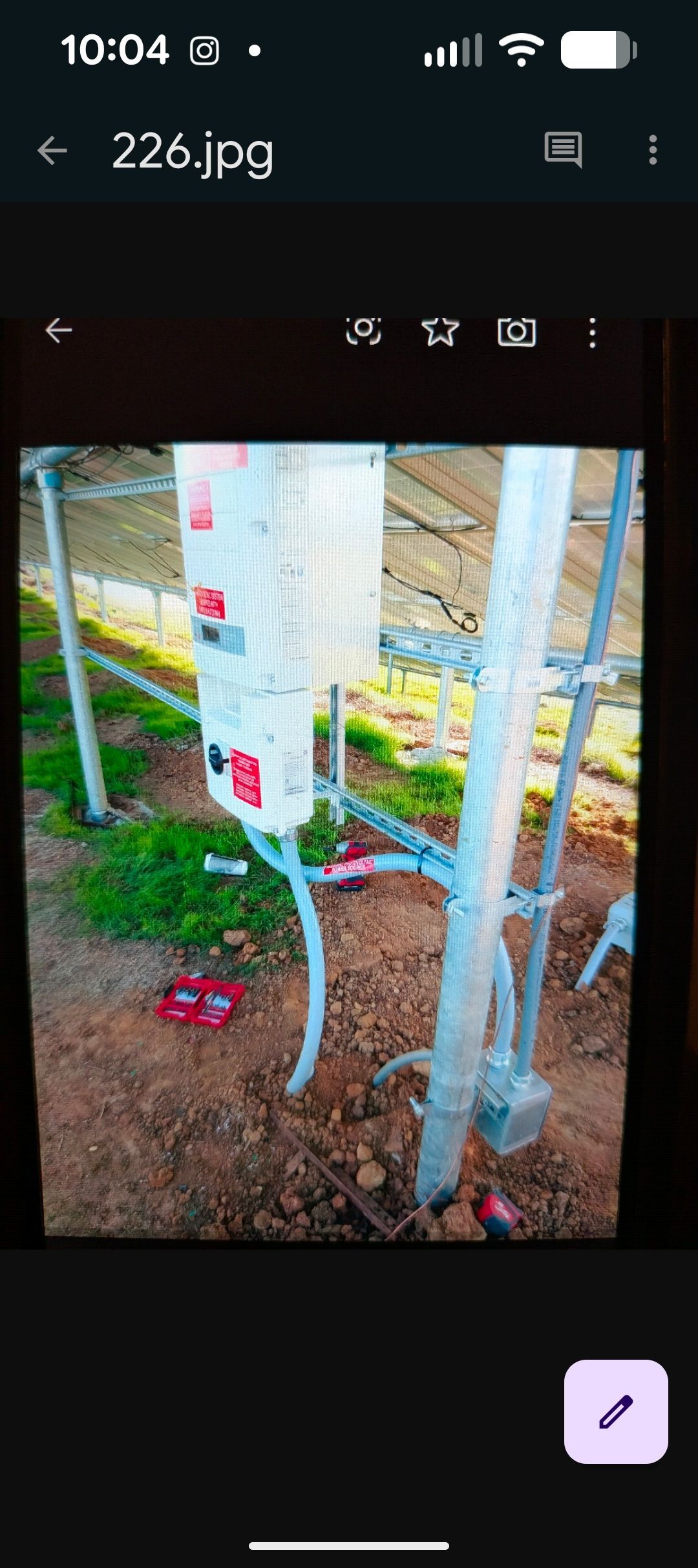 Electrician uses a multimeter to test voltage in a fuse box; reading is 236.