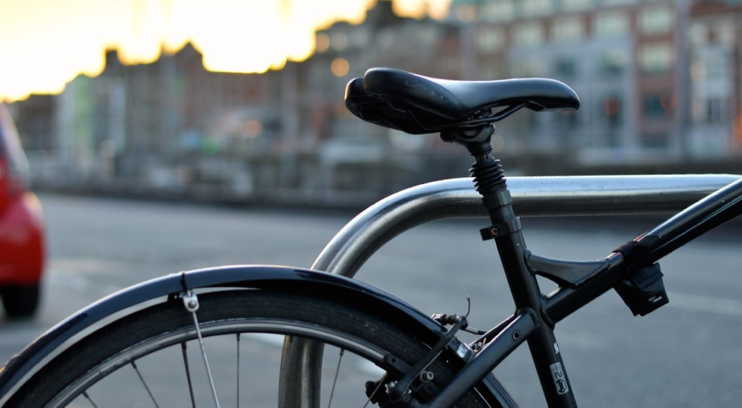 A bicycle is locked to a railing on the side of the road.