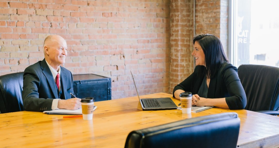 A man and a woman are sitting at a table having a conversation, representing the topic of business litigation.
