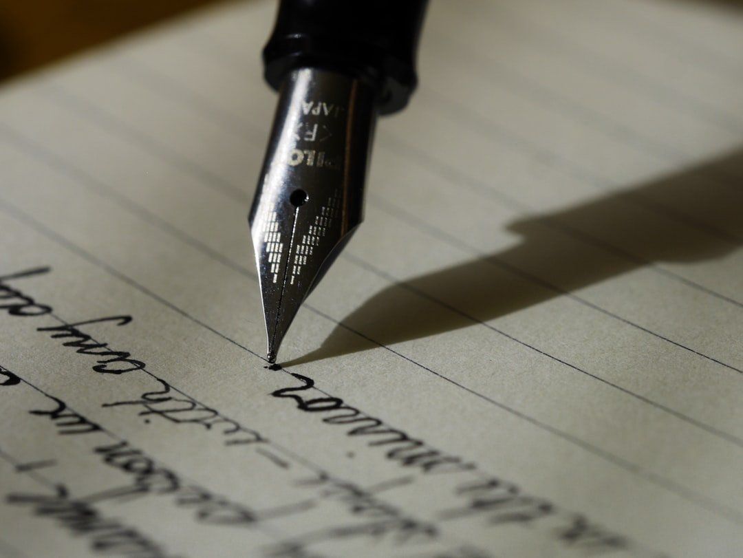 A close up of a fountain pen writing on a piece of paper, representing the topic of estate planning law.