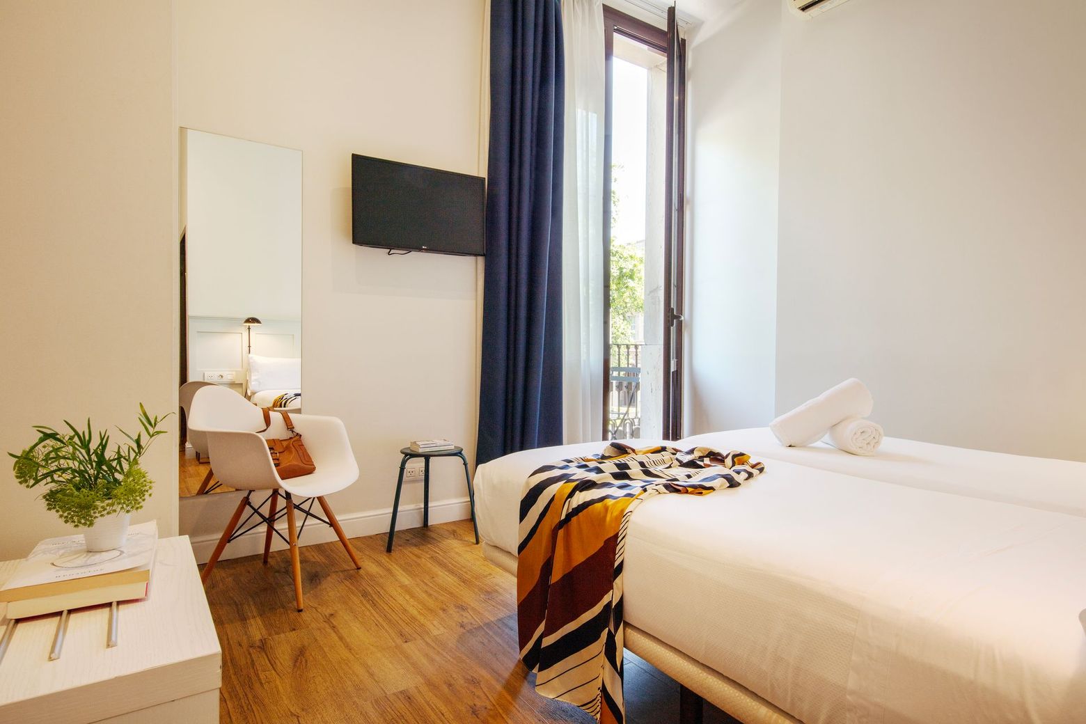 Un dormitorio con dos camas, una lámpara y una televisión.