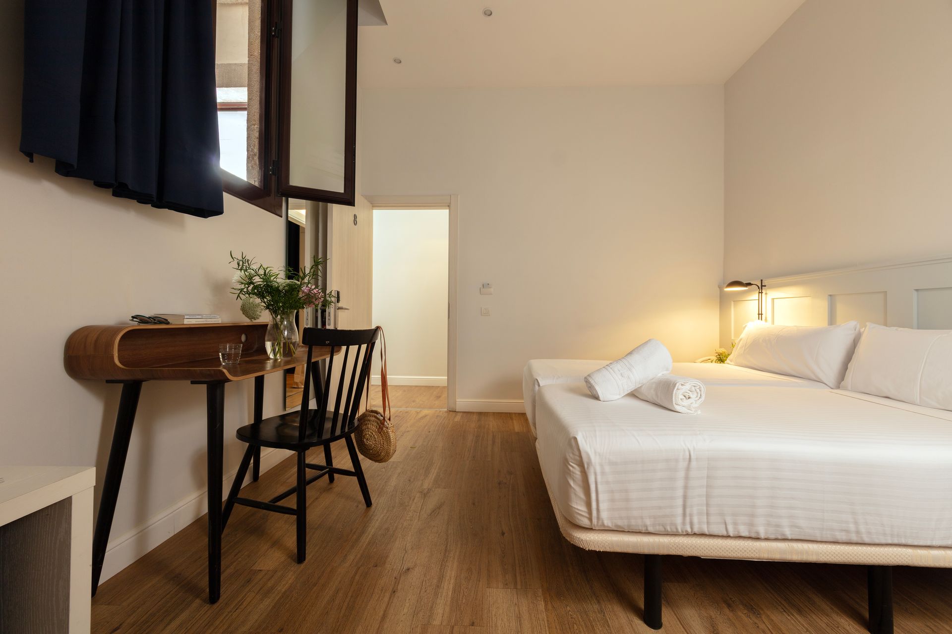 Una habitación de hotel con una cama, un escritorio y una silla.