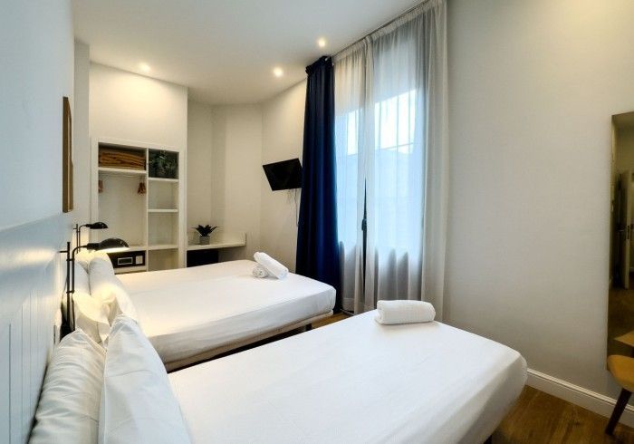 Una habitación de hotel con dos camas y una silla.