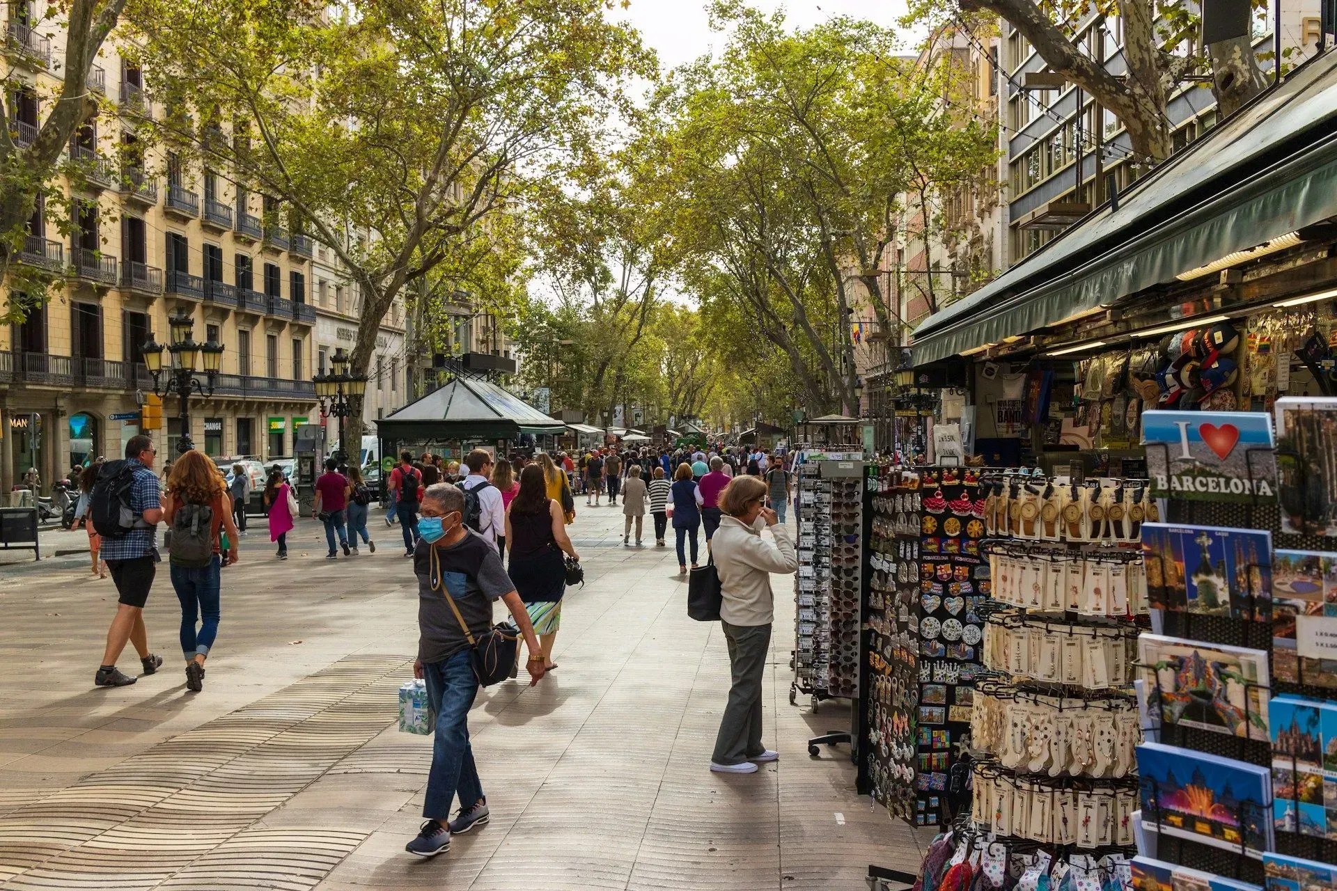 Un grupo de personas camina por una acera frente a una tienda.