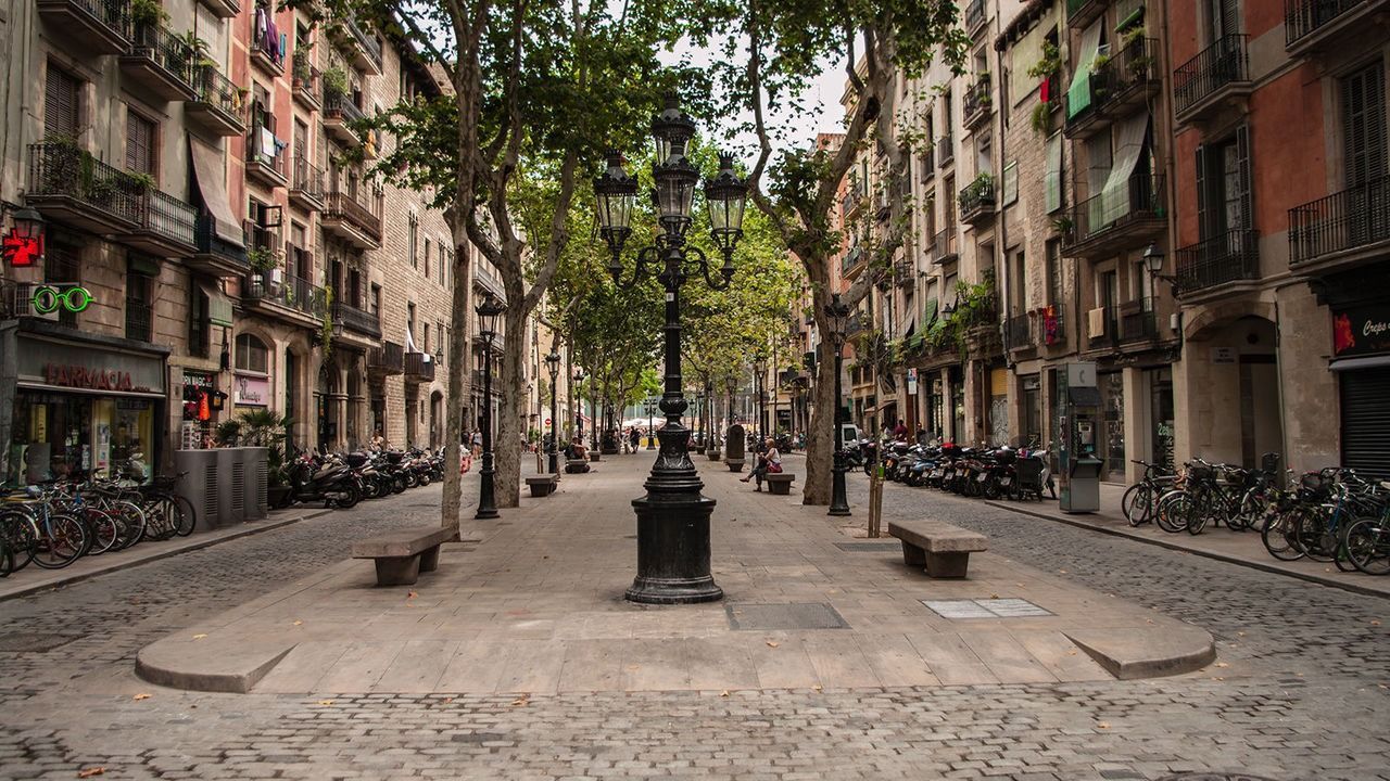 Una calle adoquinada en una ciudad con una estatua en el medio.