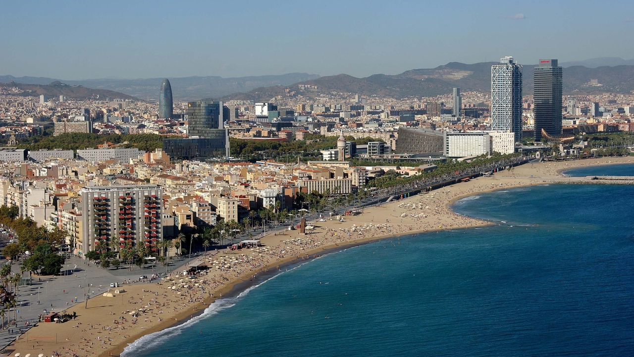 Una vista aérea de una playa con una ciudad al fondo.